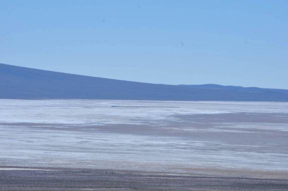 Um longo trem fica minúsculo ao atravessar o Salar de Chiguana, ao sul do Salar de Uyuni, na Bolívia